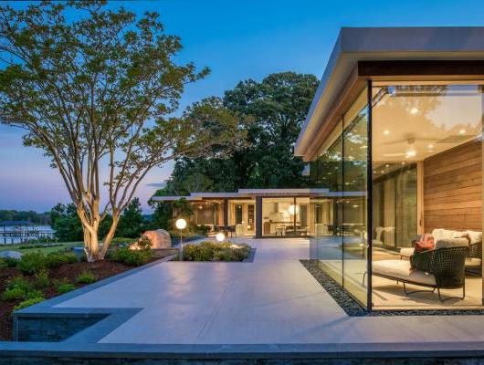 Custom home with floor to ceiling windows overlooking the water